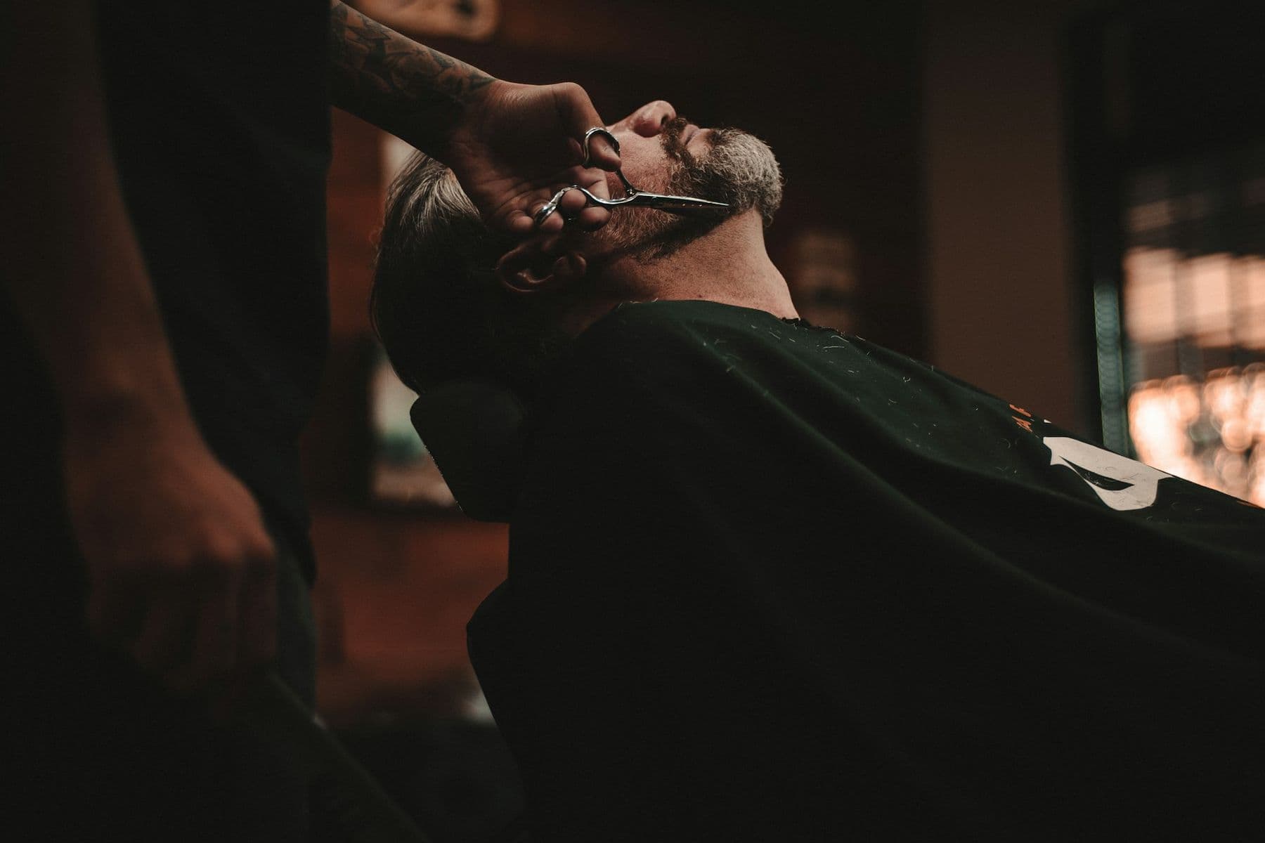 Barber taillant la barbe d'un client aux ciseaux